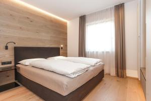 a bedroom with a large bed with a large window at Gasthof Sonne OHG in Sarntal