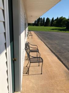 
a row of benches in front of a building at Village Inn Motel in Chatham

