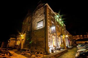 a brick building with lights on it at night at The Greyhound Hotel Cromford in Cromford