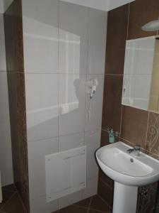 a bathroom with a white sink and a mirror at Villa Marios- Under the Volcano in Zefiría