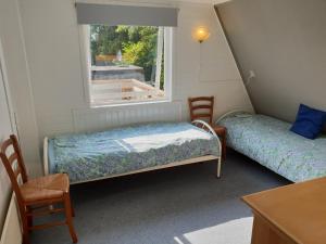 - 2 lits dans une chambre avec fenêtre dans l'établissement Appartement Soigner!, à Egmond-Binnen