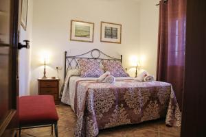 a bedroom with a bed with a purple comforter at Casa Rural Típica Andaluza, WiFi,Piscina, Barbacoa, Aire Acondicionado, 5min Centros in Alhaurín el Grande
