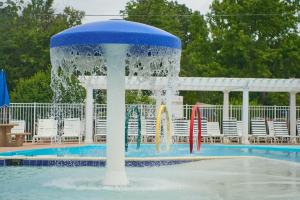 a fountain in the middle of a pool with chairs at Grey's Point Camp Cottage 7 in Locklies