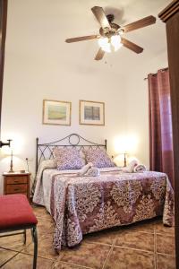 a bedroom with a bed and a ceiling fan at Casa Rural Típica Andaluza, WiFi,Piscina, Barbacoa, Aire Acondicionado, 5min Centros in Alhaurín el Grande