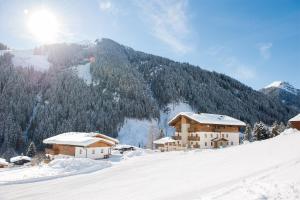 a snow covered mountain with houses on a snow covered slope at Landhaus Gensbichler in Saalbach Hinterglemm