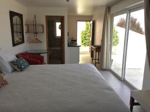 a bedroom with a large bed and a sliding glass door at Alojamiento Independiente in Zapallar