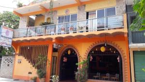 an orange building with a balcony on top of it at Casa de Huespedes Cielito Lindo in Santa Cruz Huatulco +8 photos