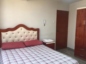 万卡约A-Hope Suite Hotel的一间卧室，床上有红色枕头