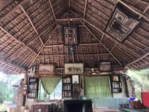 a room with a wooden ceiling with books and pictures at Maasai Simba Camp in Amboseli