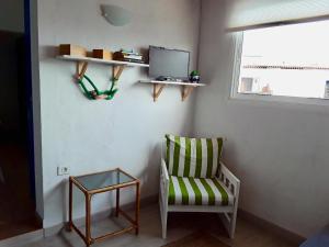 コスタ・デル・シレンチオにあるmodern bright apartment in Chayofitaのリビングルーム(椅子、テレビ付)