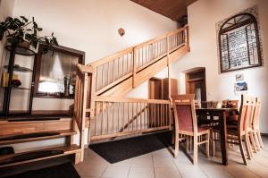 a staircase in a living room with a table and chairs at Apartmanovy Dom Martha a Domček Martuška in Liptovský Ján