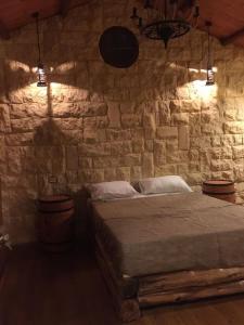 a bedroom with a stone wall with a bed at Jasmin Holiday House in Alexandria