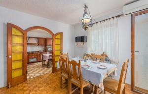 une salle à manger avec une table et une cuisine dans l'établissement HH Korsa with shared pool, à Sveti Lovreč Pazenatički