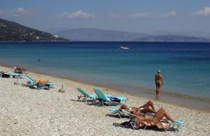 un grupo de personas tumbadas en sillas de jardín en una playa en Nautilus Barbati, en Barbati