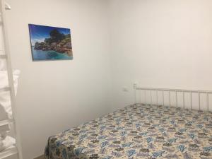 łóżko w pokoju ze zdjęciem na ścianie w obiekcie Casa Vacanze Mannina w mieście Castellammare del Golfo