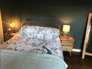 a bedroom with a bed and a night stand with a lamp at Corner House Luxury BnB in Little Dunmow