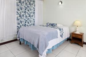
a bed room with a white bedspread and a blue wall at The Gardens in Kingston
