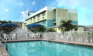 - une piscine avec des chaises et des parasols en face d'un bâtiment dans l'établissement Palm Pavilion Inn, à Clearwater Beach