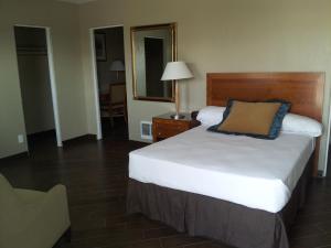 a hotel room with a bed and a mirror at Oasis Boutique Motel in Boulder City