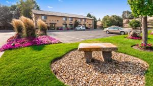 a bench sitting in the grass near a parking lot at Best Western Prineville Inn in Prineville