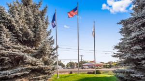 two flags on poles in a yard between two trees at Best Western Prineville Inn in Prineville