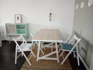 a dining room with a white table and chairs at Fisherman's Inn in Montijo