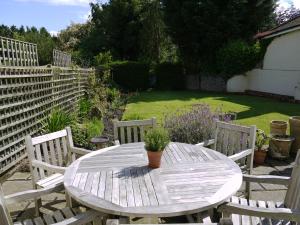 - une table et des chaises en bois dans le jardin dans l'établissement One Pelham Grove Bed & Breakfast, à Stocking Pelham