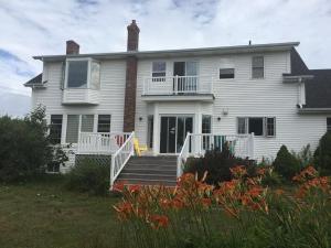 a large white house with a porch and stairs at Seaview White House in Stratford