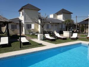 a swimming pool with lounge chairs and a house at Altos de Unzué in Gualeguaychú