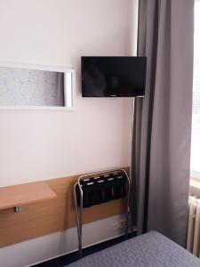 Hotel Rozvoj في كلاتوفي: غرفة نوم بسرير وتلفزيون على جدار