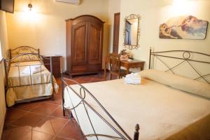 1 dormitorio con 2 camas, mesa y silla en Il Vecchio Frantoio, en Stella Cilento