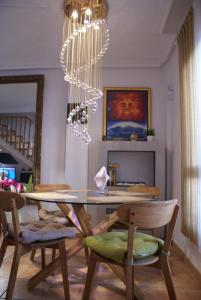 ein Esszimmer mit Tisch und Stühlen und einem Kronleuchter in der Unterkunft Oriheula Costa Cabo Roig 6 in Playas de Orihuela