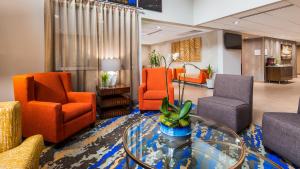a lobby with orange chairs and a glass table at Best Western Plus Portland Airport Hotel & Suites in Parkrose