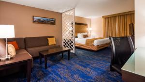 a hotel room with a couch and a bed at Best Western Plus Portland Airport Hotel & Suites in Parkrose