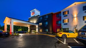 a yellow car parked in a parking lot in front of a hotel at Best Western Plus Portland Airport Hotel & Suites in Parkrose