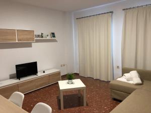 - un salon avec un canapé et une télévision dans l'établissement Apartamentos nueva 13, à Ronda