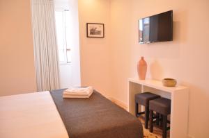 a small room with a television and a bed at Mystay Porto Batalha in Porto