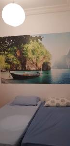 1 dormitorio con una pintura de un barco en la pared en Douja Apartment, en Nabeul