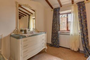 1 dormitorio con tocador y espejo en Casa il Castello, en Gambassi Terme