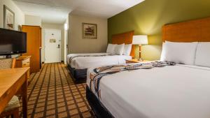 ein Hotelzimmer mit zwei Betten und einem Flachbildfernseher in der Unterkunft Best Western Plus Chicago Hillside in Hillside