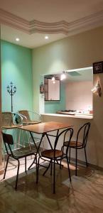a dining room with a table and chairs and a kitchen at Douja Apartment in Nabeul