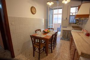 a kitchen with a table with chairs and a clock on the wall at Casa della nonna in Riposto