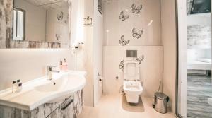 a bathroom with a sink and a toilet and butterflies on the wall at Nur Hotel in Kaş
