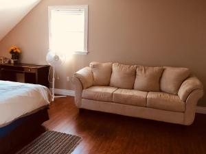 a couch in a room with a bed and a window at Seaview White House in Stratford