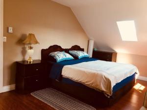 a bedroom with a bed with blue and white sheets at Seaview White House in Stratford