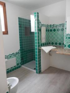 a green tiled bathroom with a sink and a shower at La Costa Est Villa con Vista Mare in Ogliastra Sardegna in Tertenìa +52 photos