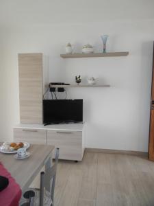 a living room with a dining table and a kitchen at La Costa Est Villa con Vista Mare in Ogliastra Sardegna in Tertenìa