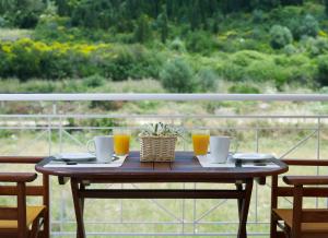 a wooden table with glasses of orange juice on a balcony at Muses Studios Sami in Sami