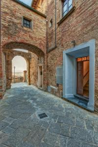 un callejón con un edificio de ladrillo con un arco en Casa il Castello, en Gambassi Terme