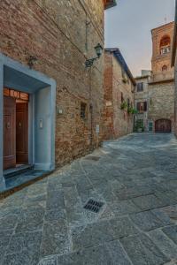 an alley with a brick building and a door at Casa il Castello in Gambassi Terme